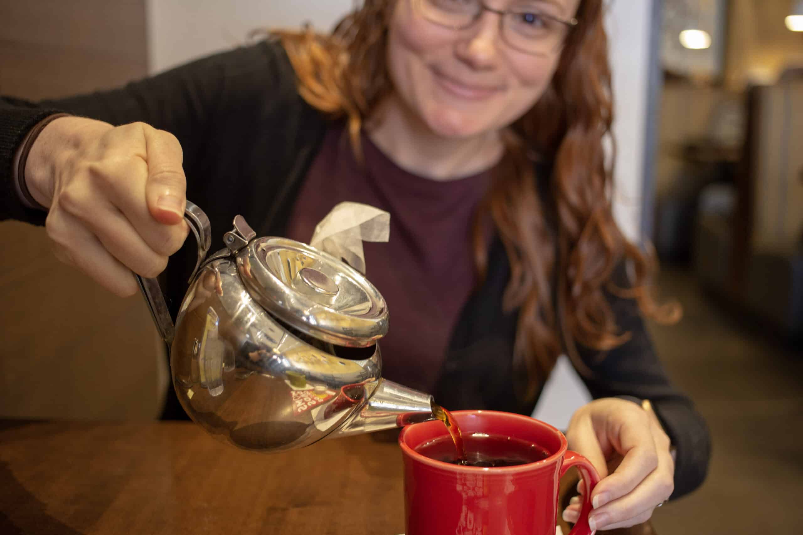 rebekah pouring a mug of tea from silver teapot